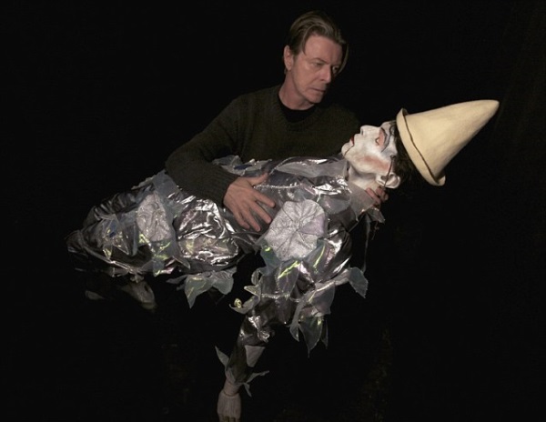 David Bowie ținând în brațe păpușa care amintește de clipul "Ashes To Ashes"