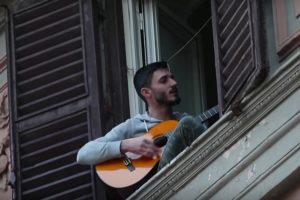 Un tânăr italian cântând de la balcon